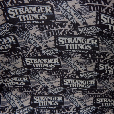 Tecido padrão preto e branco com texto STRANGER THINGS repetido.