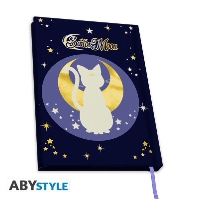 Caderno azul escuro com gato e lua dourada e estrelas, texto Sailor Moon