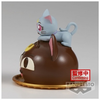 Objeto decorativo de chocolate com figura de gato azul em cima sobre base dourada