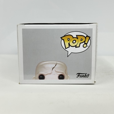 Caixa Funko Pop com imagem parcial de figura careca e cicatrizes.