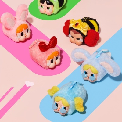Bags or keychains with plush doll heads in bunny, bee, and animal costumes on colorful background.