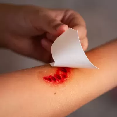 Braço a remover tatuagem temporária vermelha com padrão de lábios