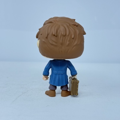 Figura colecionável de plástico com casaco azul a segurar mala