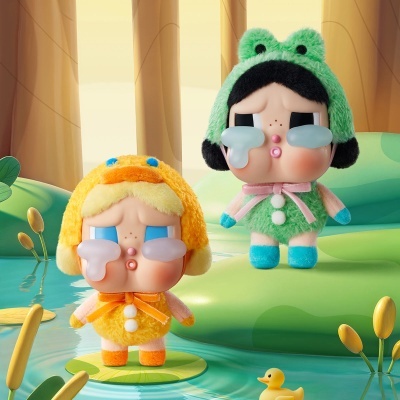Dois bonecos peludos a chorar, um verde com orelhas de sapo e outro amarelo com capuz de pato, em cenário de lago e plantas.