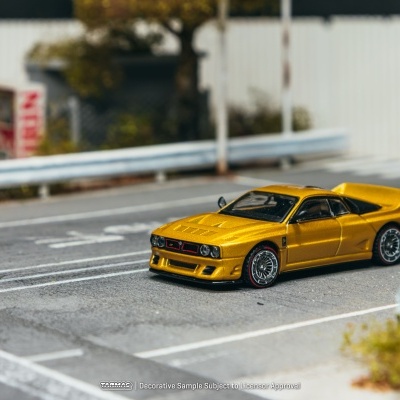Miniatura de carro desportivo amarelo numa réplica de estrada com guardas-rodas.