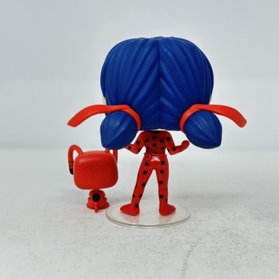 Brinquedo figura com cabelo azul e roupa vermelha com manchas pretas