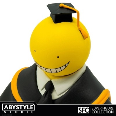 Figura decorativa amarela sorridente com toga preta e amarela e toca de formatura com pompom amarelo