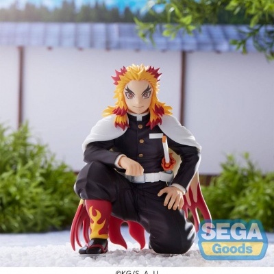 Figura colecionável com cabelo amarelo e vermelho, uniforme preto, capa branca e calças com chamas, em cenário exterior
