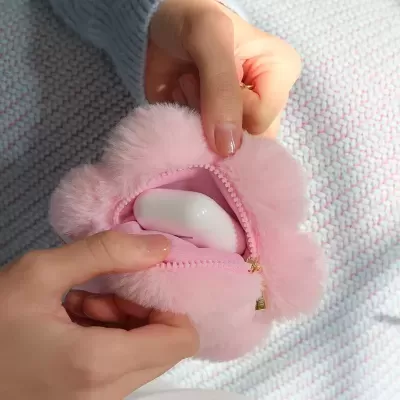 Bolsa rosa de pelúcia com fecho de correr dourado e caixa branca dentro