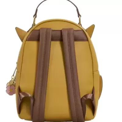 Mochila amarela com alças castanhas e pendente em forma de flor cor-de-rosa