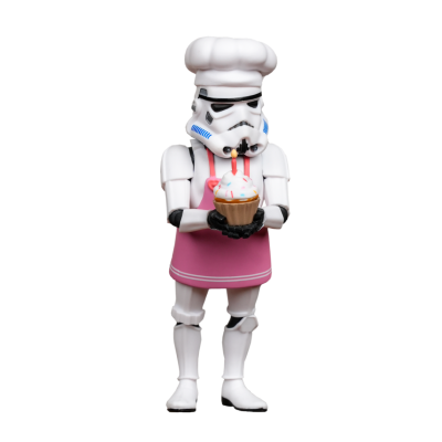 Stormtrooper em avental cor-de-rosa e chapéu de cozinheiro segurando muffin com vela.
