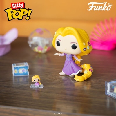 Figura Funko Pop! personagem com vestido roxo e cabelo amarelo com flores coloridas sobre superfície de madeira