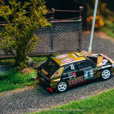 Miniatura de carro de corrida preto e dourado em cenário de estrada