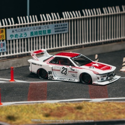 Miniatura de carro de corrida branco e vermelho com número 23 numa pista com cones laranja e vedação branca.