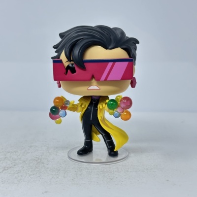 Figura Funko Pop com cabelo preto, óculos rosas, casaco amarelo e bolas coloridas nas mãos