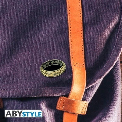 Mochila roxa com alça de couro castanho e pin metálico redondo com inscrições douradas