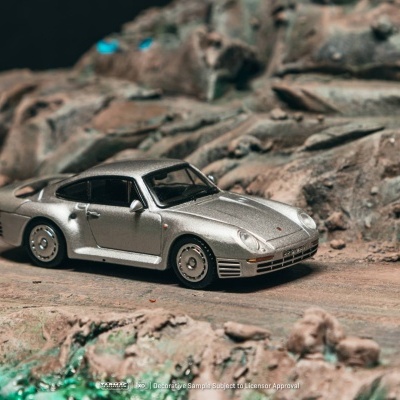 Miniatura de carro desportivo prateado sobre terreno rochoso em miniatura