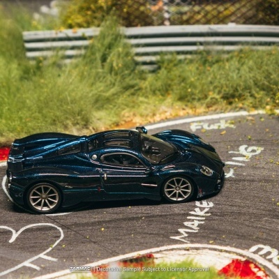 Miniatura de carro desportivo azul metálico numa pista de corrida com marcações