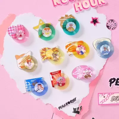 Pins decorativos coloridos com desenhos animados e texto PEACH RIOT sobre fundo rosa e branco