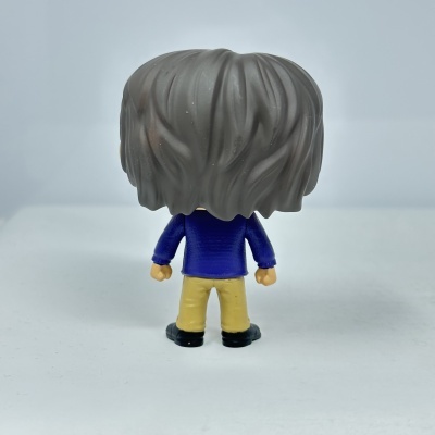 Figura de vinil estilizada vista de costas com casaco azul e cabelo cinzento