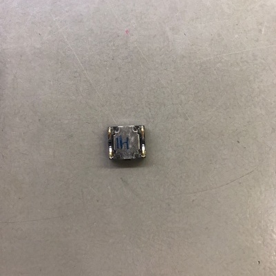 Componente eletrônico quadrado metálico com símbolo azul