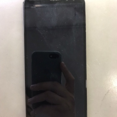 Smartphone preto Huawei com ecrã táctil sobre superfície clara