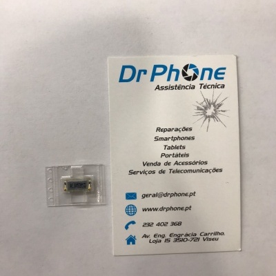 Componente eletrónico pequeno em embalagem plástica ao lado de cartão de visita da Dr Phone Assistência Técnica