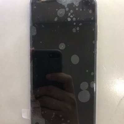 Smartphone preto manchado sobre superfície branca