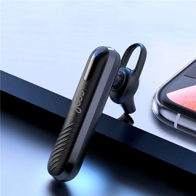 Auricular Bluetooth preto e smartphone sobre superfície preta