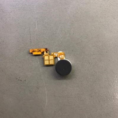 Componente eletrónico pequeno com parte circular preta em fundo cinzento