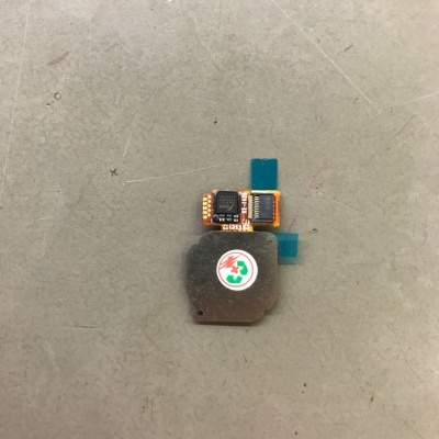 Peça eletrónica pequena com componente metálico e circuito impresso