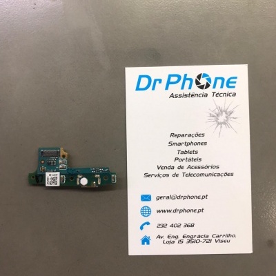 Placa eletrónica azul com componentes e cartão de visita da assistência técnica Dr Phone