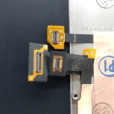 Placa eletrónica com conectores flexíveis e etiquetas num fundo metálico