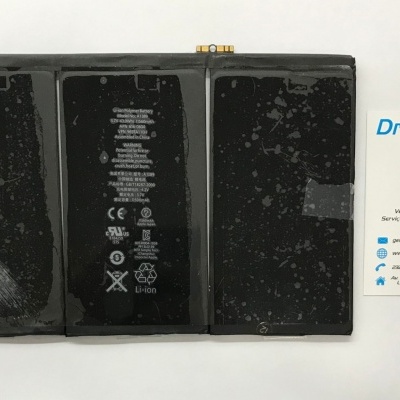 Bateria preta de smartphone com texto e símbolos, ao lado de cartão de visita da DrPhone