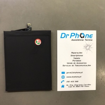 Bateria preta e cartão de visita da Dr Phone sobre superfície cinzenta
