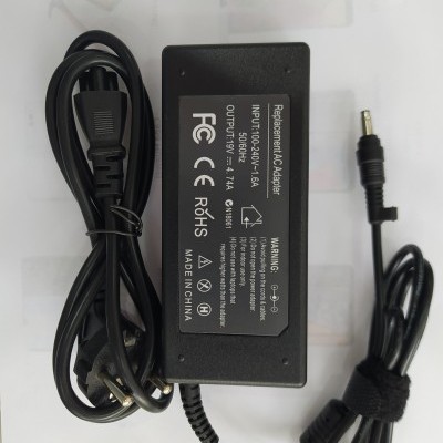 Adaptador de corrente preto com cabo e etiquetas técnicas