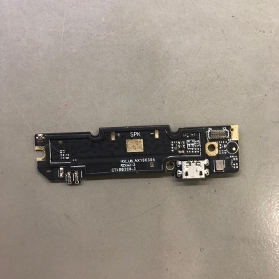 Placa eletrónica preta com conector USB branco sobre superfície cinzenta