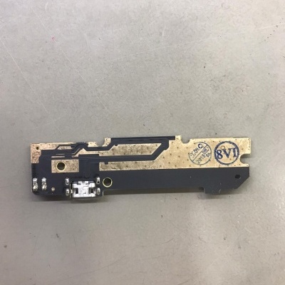 Peça eletrónica com circuito dourado, porta USB e carimbos azuis