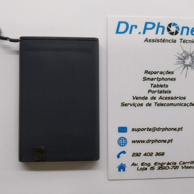 Bateria preta retangular ao lado de cartão de visita da Dr.Phone para assistência técnica