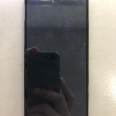 Smartphone preto com ecrã táctil sobre superfície clara