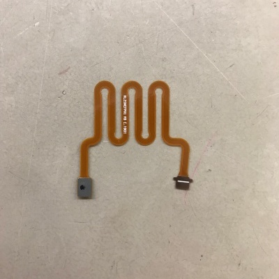 Flexível eletrónico laranja com três laços em superfície branca-marrom clara