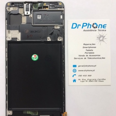 Smartphone desmontado com bateria e peça interna visível ao lado de cartão de visita da Dr Phone Assistência Técnica