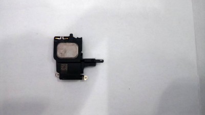 Componente eletrônico preto com parte metálica prateada numa superfície branca