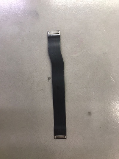 Cabo plano flexível preto com conectores metálicos em fundo cinzento