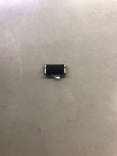 Componente eletrónico pequeno sobre superfície cinzenta