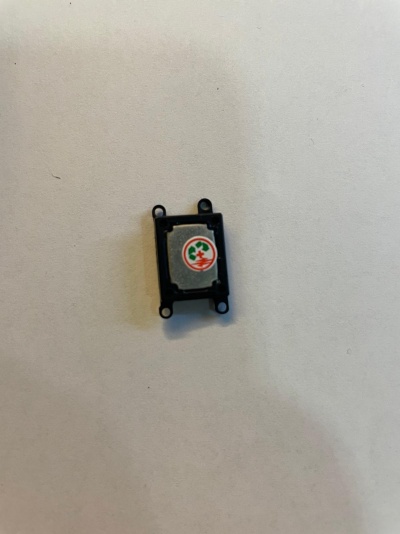 Componente eletrónico preto com etiqueta circular colorida sobre fundo branco.