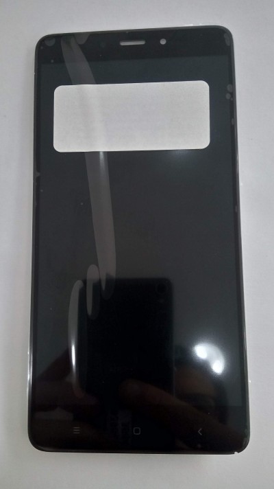 Smartphone preto com autocolante branco no ecrã sobre superfície branca