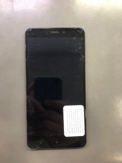 Smartphone preto com autocolante branco no ecrã