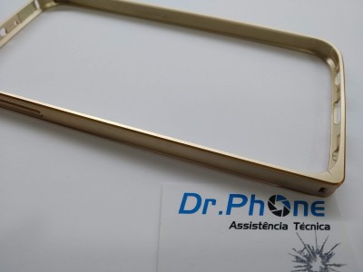 Moldura dourada para smartphone sobre superfície branca com cartão de assistência técnica