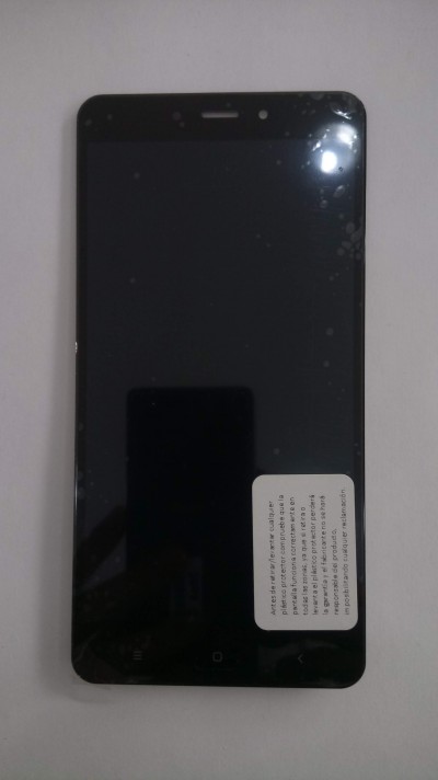 Smartphone preto com ecrã desligado e adesivo branco na frente